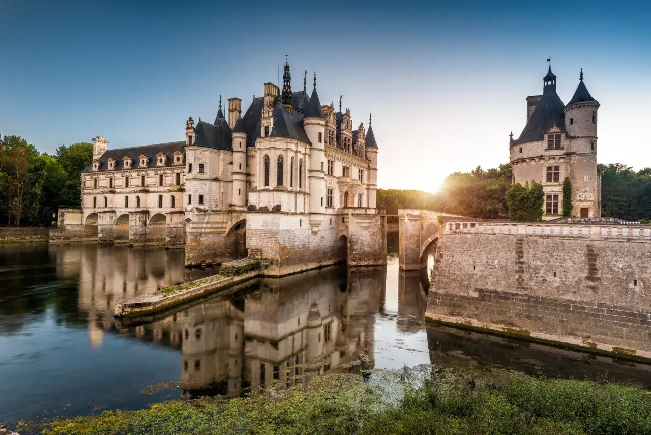 Le ch&acirc;teau de Chenonceau, un magnifique ch&acirc;teau de la Loire, se refl&egrave;te dans l'eau. Imaginez y arriver en camping-car pour une nuit inoubliable.