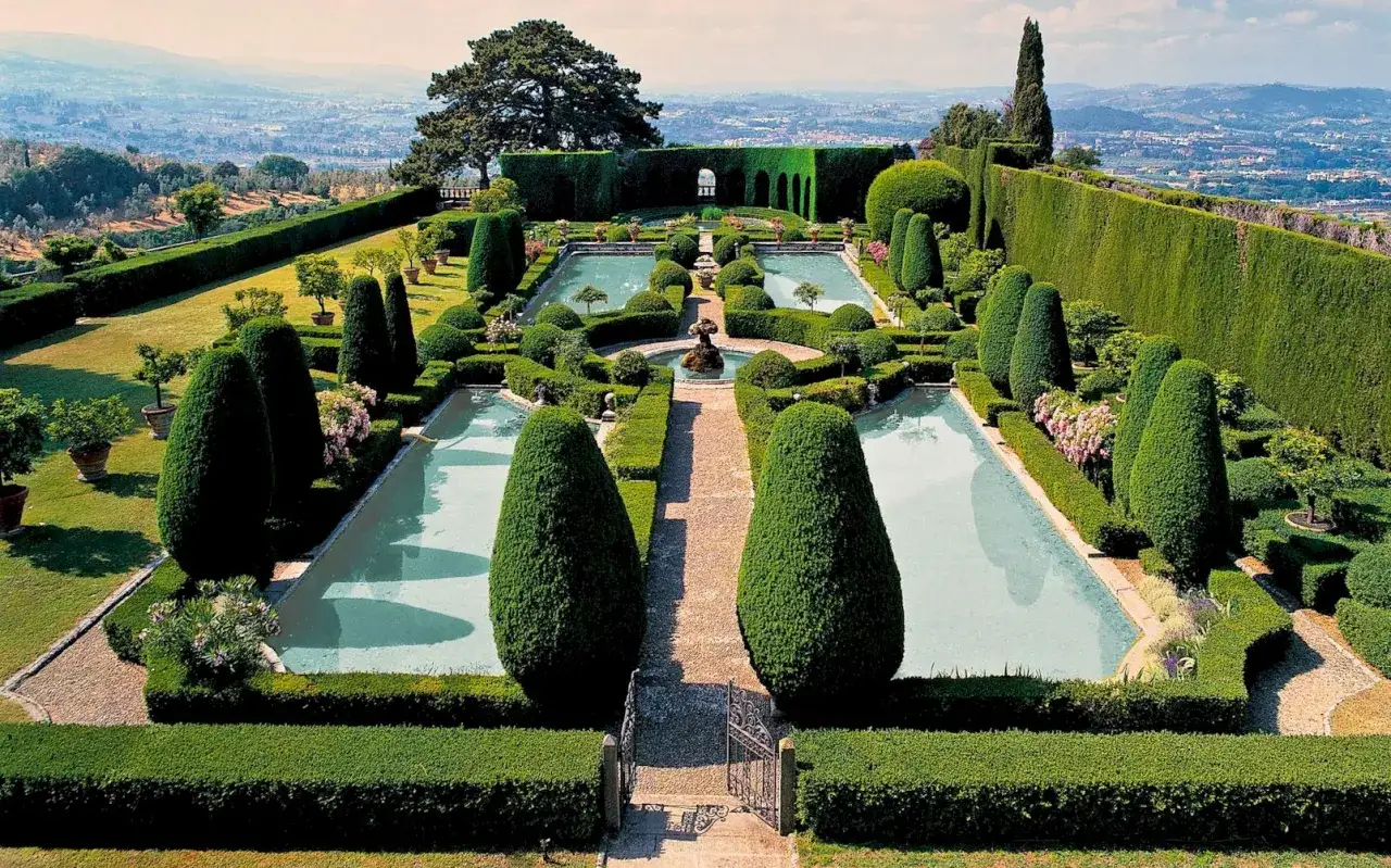 Jardins à la française de la Villa Reale di Marlia, avec bassins, fontaines et topiaires taillés avec précision, offrant une vue panoramique sur la Toscane.