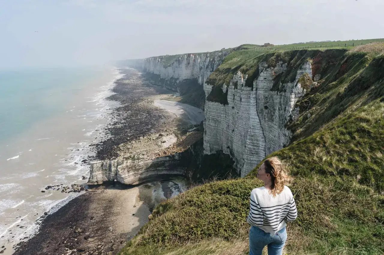 Une femme admire les falaises blanches spectaculaires, une belle invitation à partir en week-end.