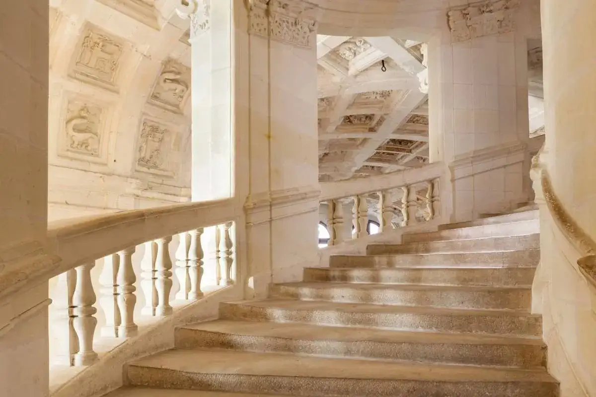 Escalier monumental du château de Chambord, avec ses balustres sculptés et ses plafonds ornés.