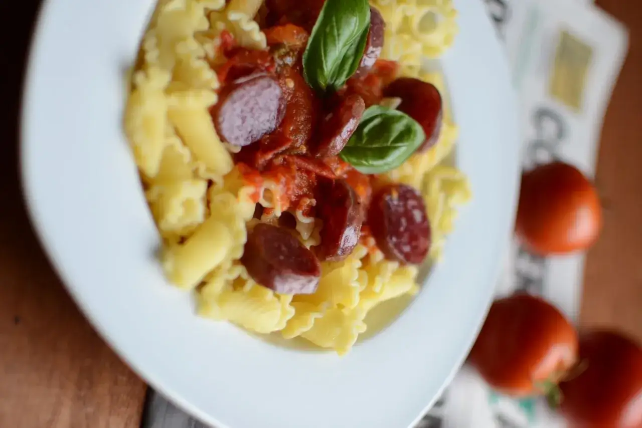 P&acirc;tes pici all'aglione avec des rondelles de saucisse, sauce tomate et basilic frais. Un plat savoureux et color&eacute;.