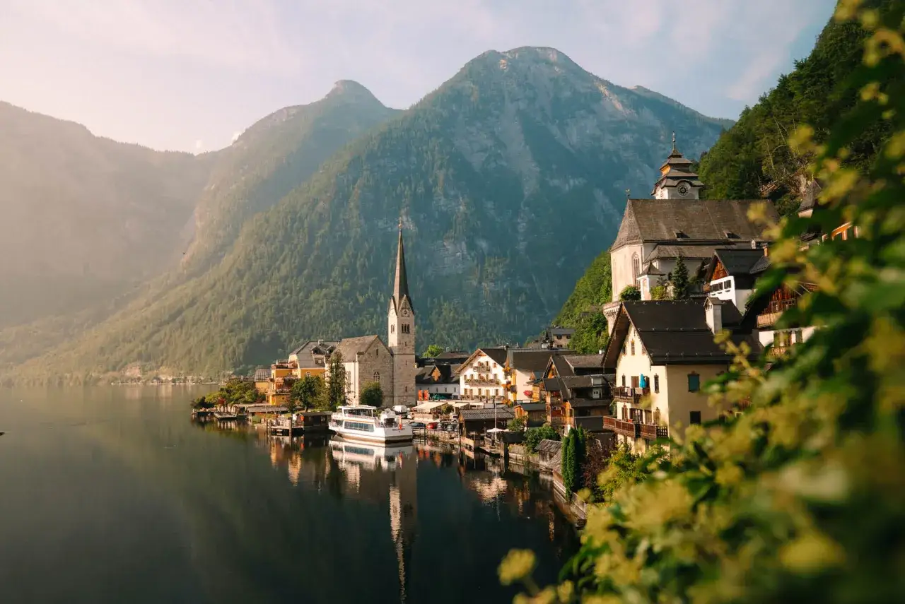 Village autrichien pittoresque au bord d'un lac, avec des montagnes en arrière-plan. Parfait pour un road trip autriche.