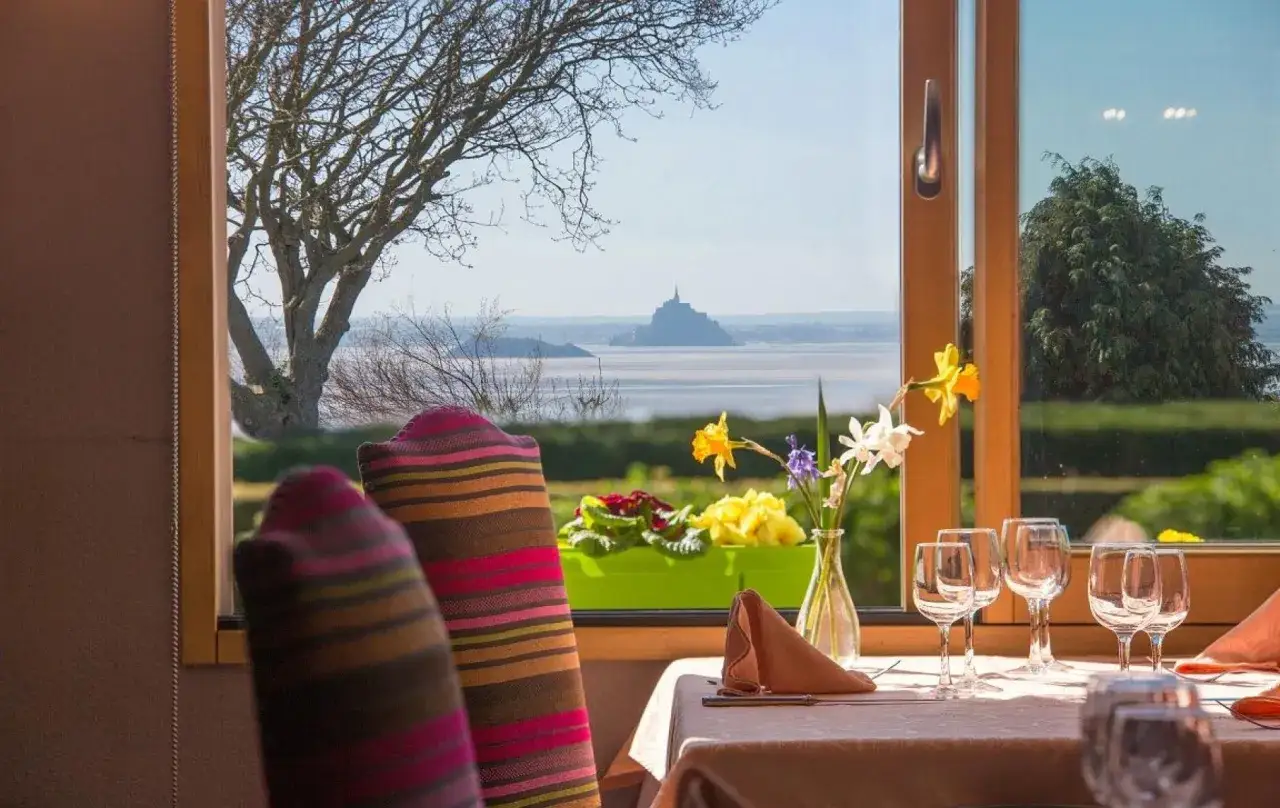 Table dressée avec vue sur le Mont Saint-Michel. Idéal pour savoir où manger au Mont Saint-Michel.