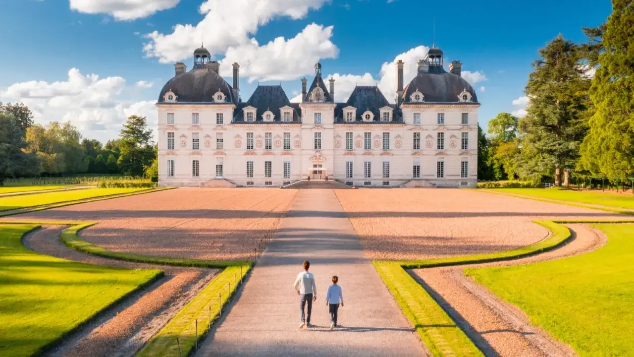 Un couple marche vers un majestueux château de la Loire, un décor digne d'une aventure de Tintin.