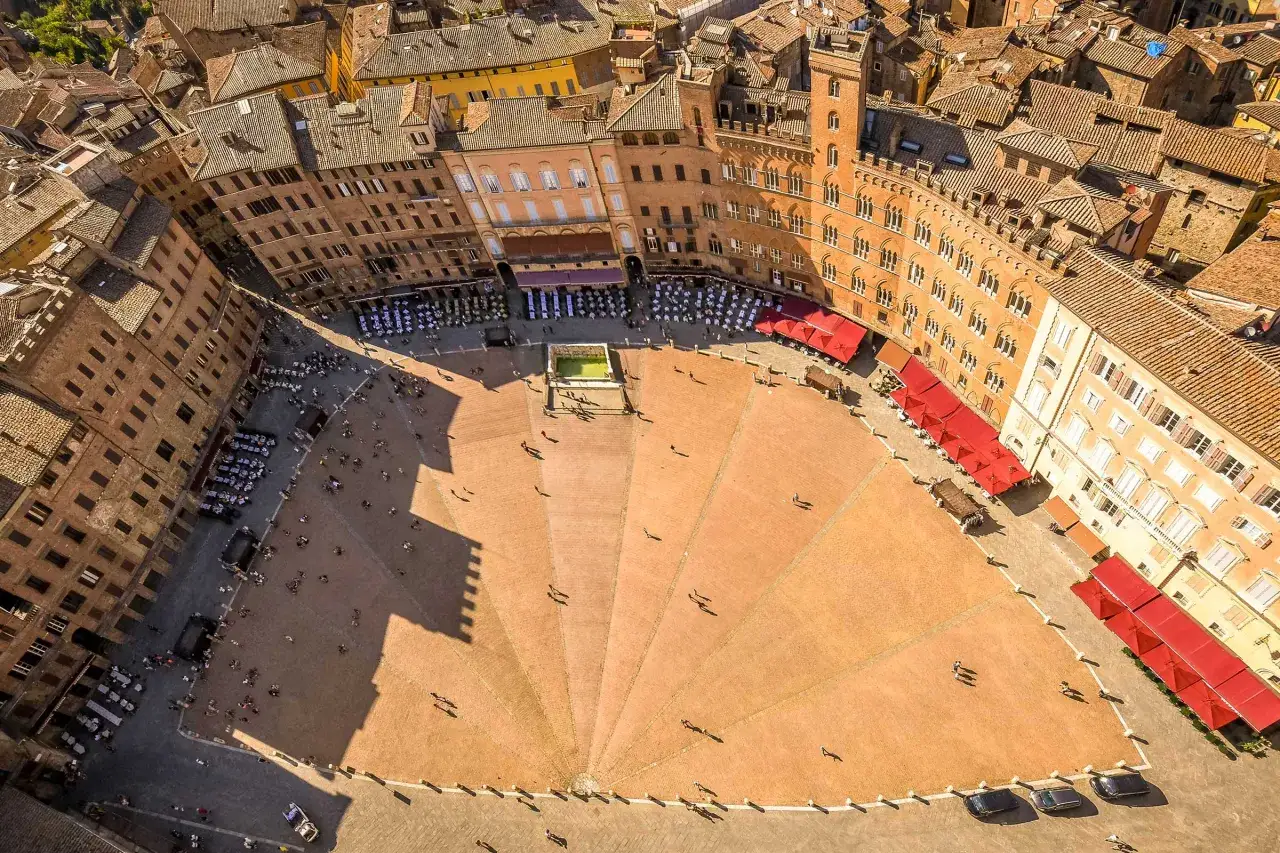 Vue aérienne de la Piazza del Campo à Sienne, parfaite pour visiter Sienne en 2 jours. Les bâtiments médiévaux et les terrasses de café invitent à la flânerie.