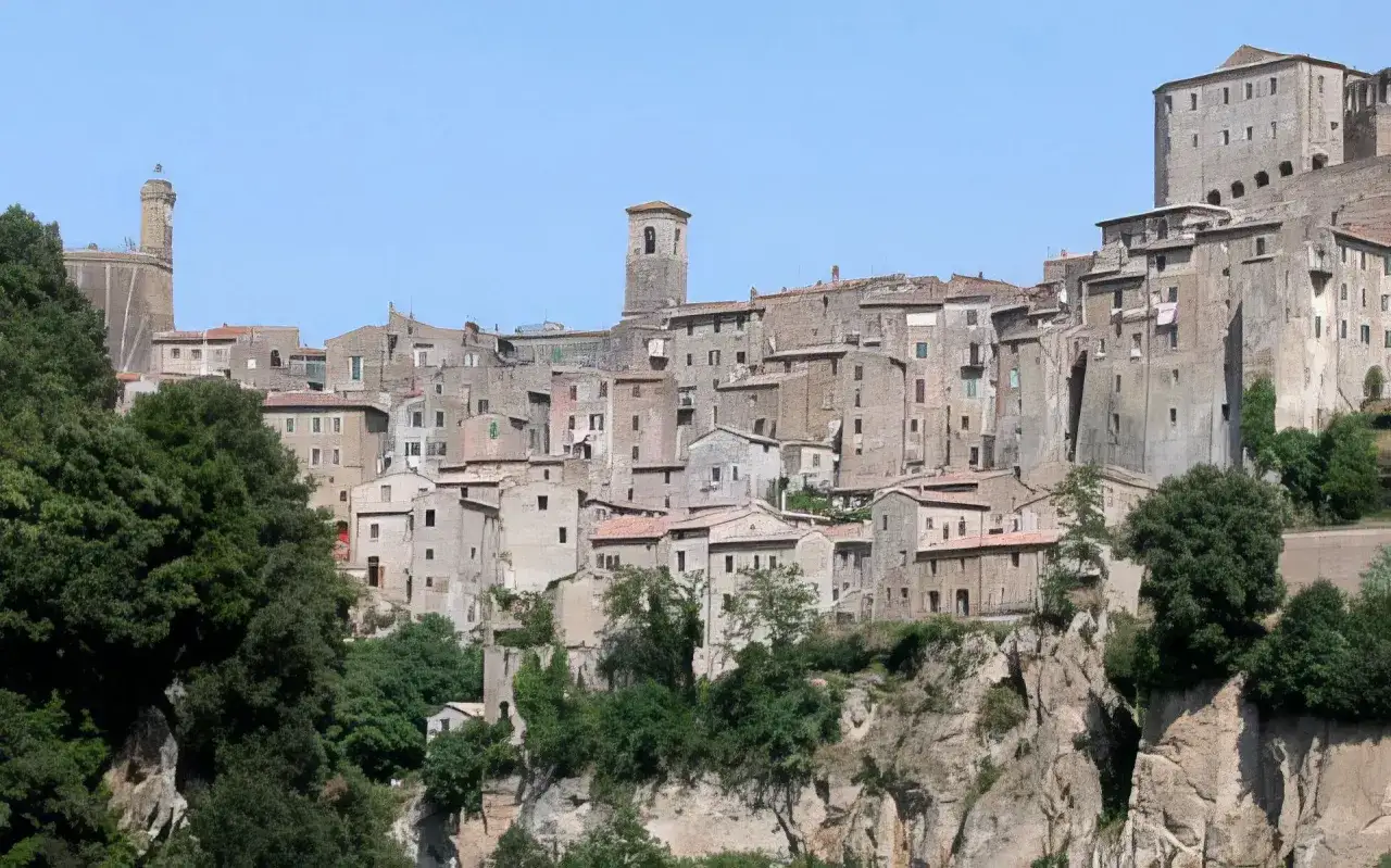 Vue panoramique de Sorano, Italie, un village médiéval perché sur une falaise, avec ses maisons en pierre et son clocher.