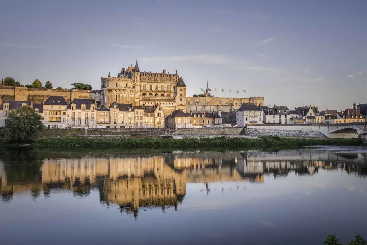 Le château d'Amboise se reflète dans la Loire au coucher du soleil. Une belle image pour planifier la durée de votre visite au château d'Amboise.