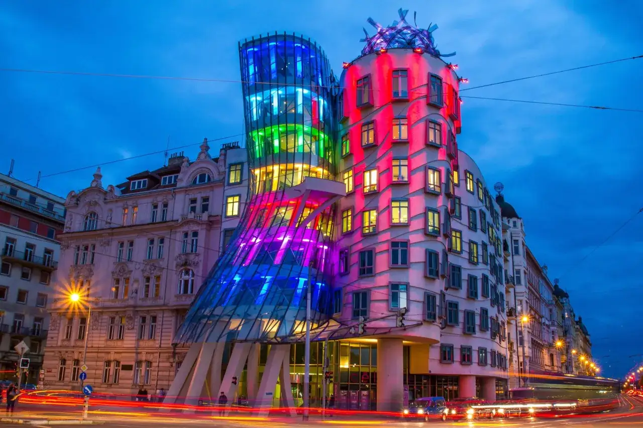La Maison Dansante à Prague s'illumine de couleurs vives, comme une œuvre d'art architecturale en mouvement dans la nuit.
