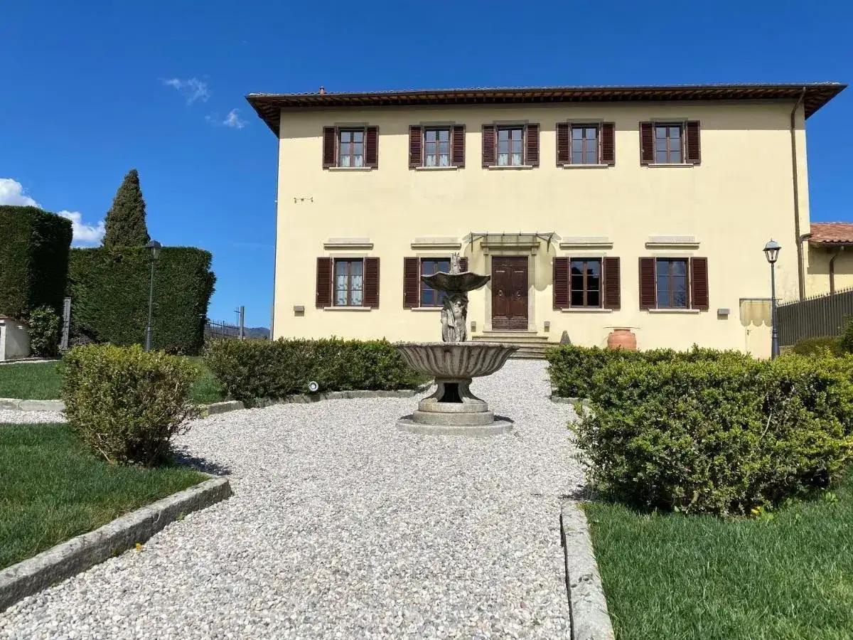 Maison toscane jaune avec fontaine et jardin soigné à Barberino di Mugello.