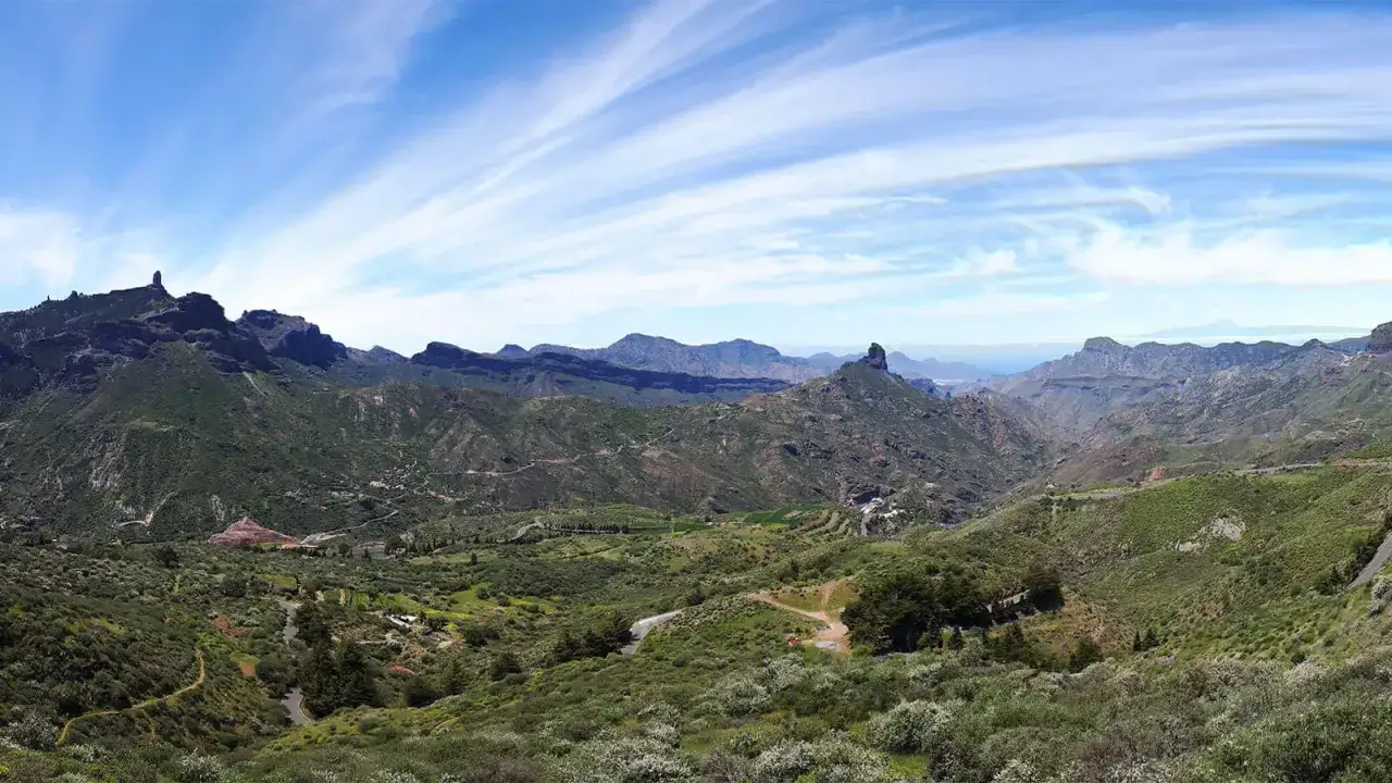 Paysage montagneux verdoyant des Canaries, idéal pour savoir que visiter aux Canaries. Des routes sinueuses traversent la vallée.