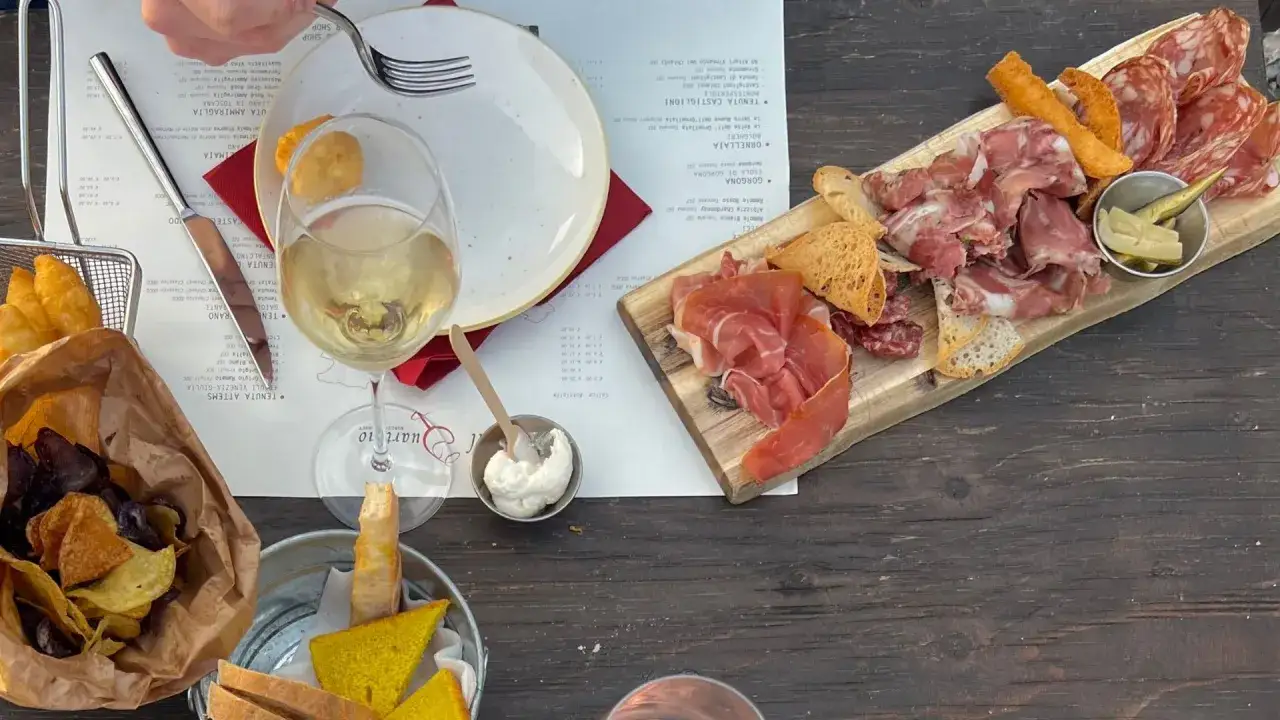 Assiette de charcuterie et de fromage, avec du vin blanc, dans un vignoble de la province de Grosseto.