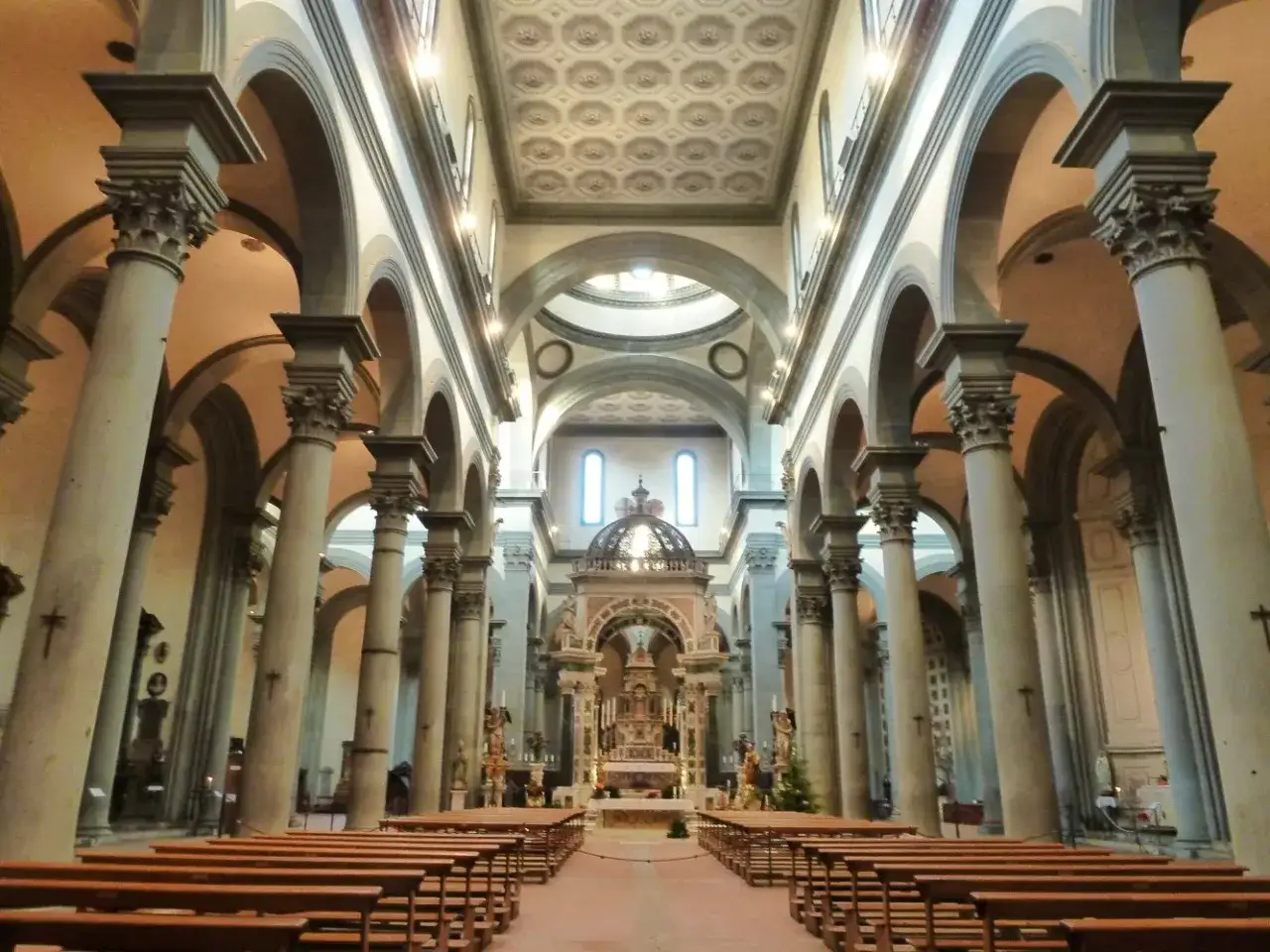 Int&eacute;rieur de la basilique Santo Spirito &agrave; Florence, avec ses colonnes imposantes, ses arches et son autel majestueux.