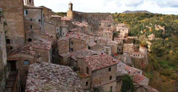 Vue panoramique de Sorano, Italie, un village médiéval perché sur une falaise, avec ses maisons en pierre et ses toits de tuiles rouges.
