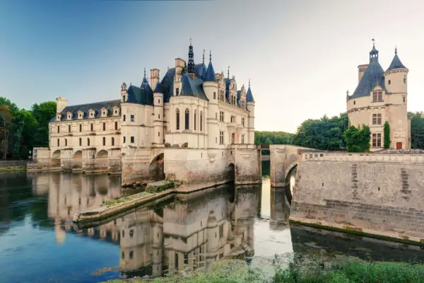 Le château de Chenonceau, joyau des châteaux de la Loire, s'avance sur le Cher, ses reflets dans l'eau évoquant une scène de conte de fées.