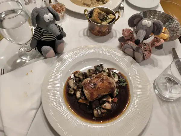 Deux peluches souris dégustent un plat de viande et champignons dans un restaurant Prague pas cher.
