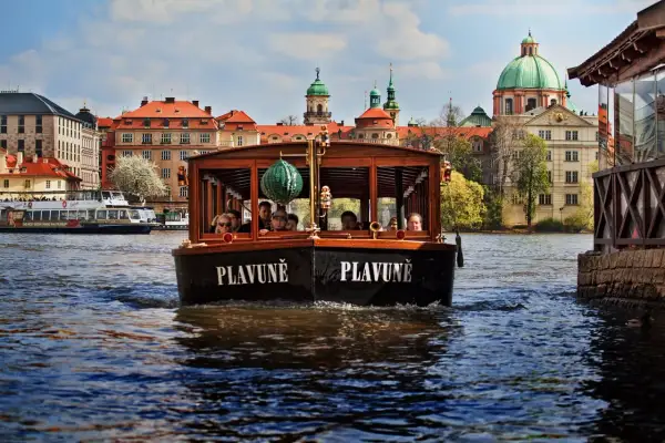 Une croisière à Prague sur le bateau "Plavuně" offre une vue magnifique sur les bâtiments historiques et les dômes verts.
