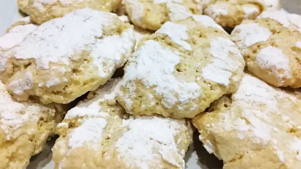 Gros plan sur des biscuits ricciarelli faits maison, saupoudrés de sucre glace. Une délicieuse recette à essayer !