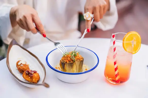 Un plat d'artichaut garni, des croquettes et un cocktail fruité dans un restaurant à Grenade.