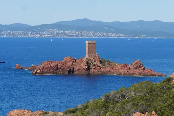 La tour du Guetteur se dresse fièrement sur la roche rouge de Saint-Raphaël, dominant la mer Méditerranée.