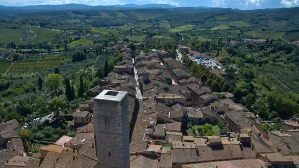 Vue aérienne de Panzano in Chianti, un village toscan pittoresque avec des toits de tuiles, des vignobles et des oliveraies verdoyantes.