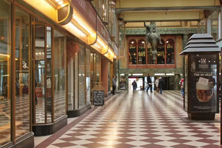 Passage Lucerna à Prague, avec son sol à damier, ses vitrines et une statue équestre.