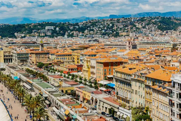 Vue panoramique de Nice, avec ses toits orangés et la colline verdoyante en arrière-plan. Parfait pour un week-end nice.